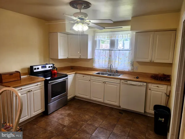 a kitchen with granite countertop a stove sink and cabinets