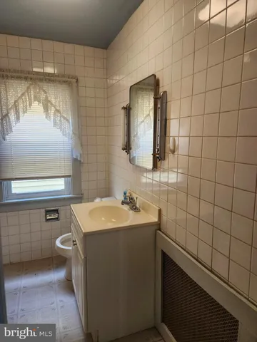 a bathroom with a sink a toilet and mirror