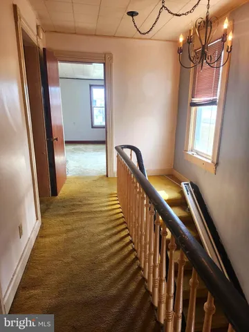 a view of a hallway with wooden floor and stairs