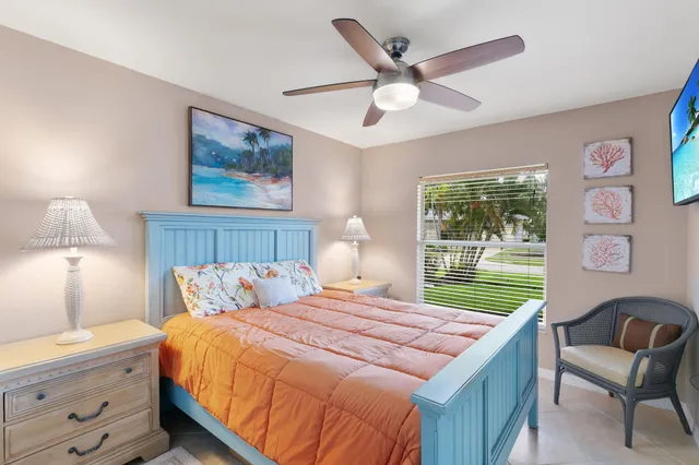 a bedroom with a large bed and a chandelier fan