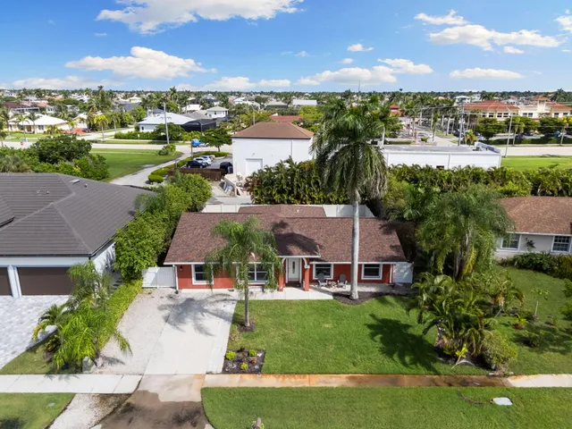 an aerial view of a city with lots of residential buildings ocean and mountain view in back