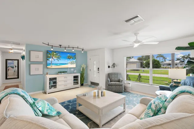 a living room with furniture and view of kitchen