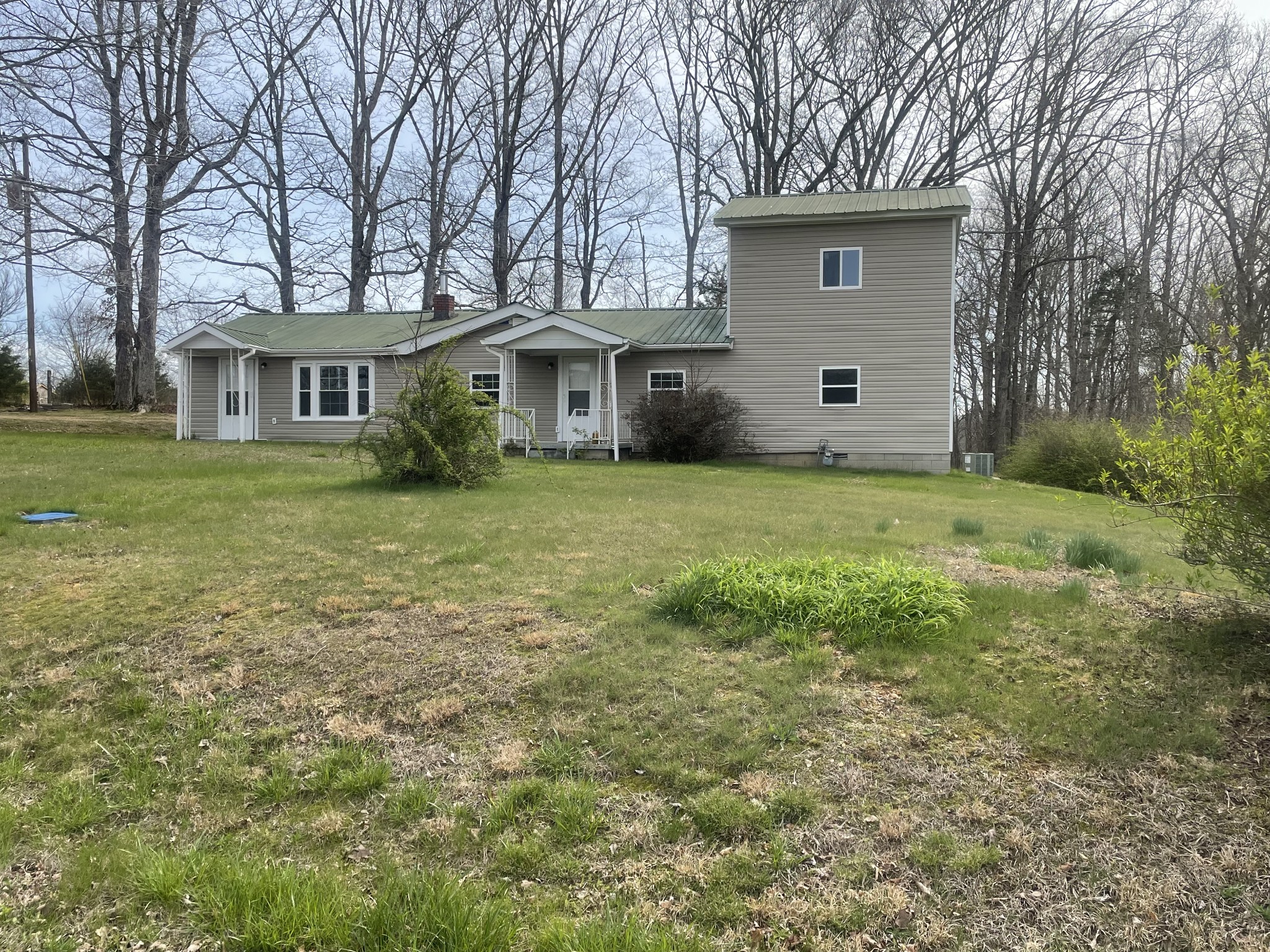 a view of a yard in front of a house with large trees