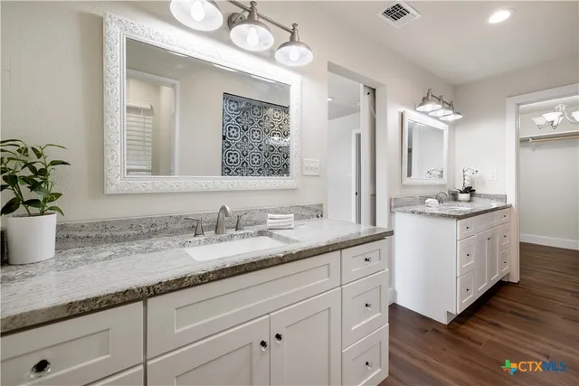 a bathroom with a granite countertop sink mirror and vanity