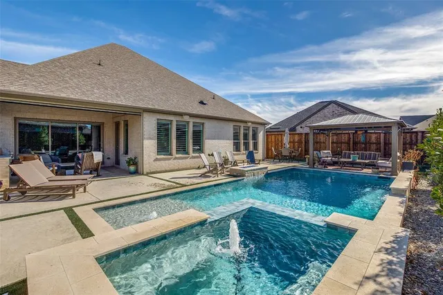 a view of a house with swimming pool and sitting area