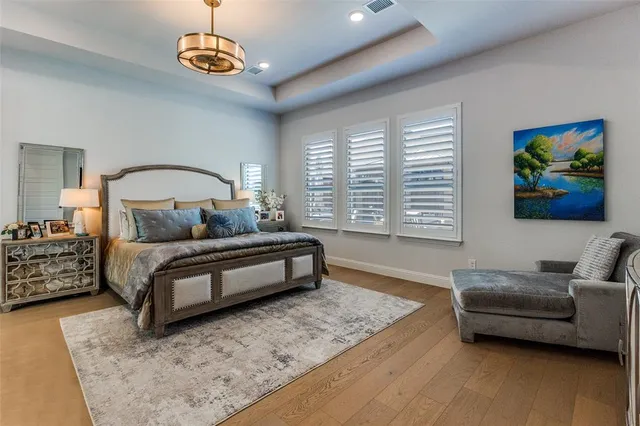 a bedroom with a bed a couch and a chandelier