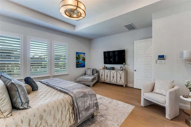 a spacious bedroom with a bed a couch and a flat screen tv