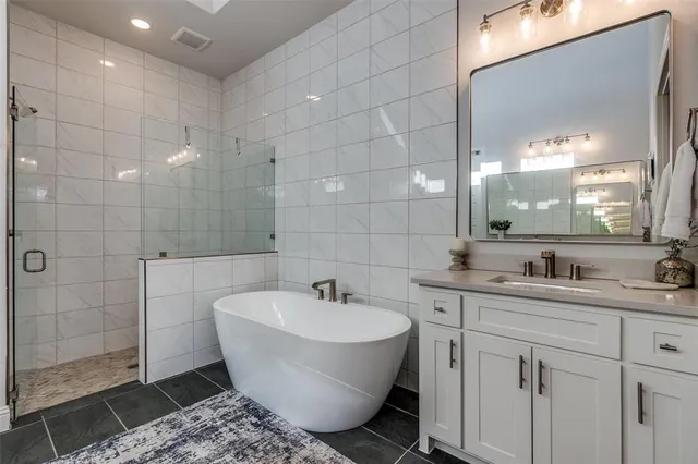 a bathroom with a sink and mirror with bathtub