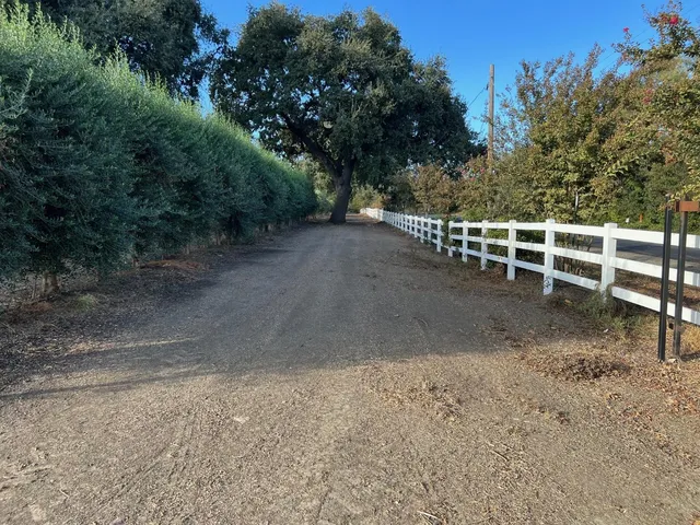a view of a yard with wooden fence