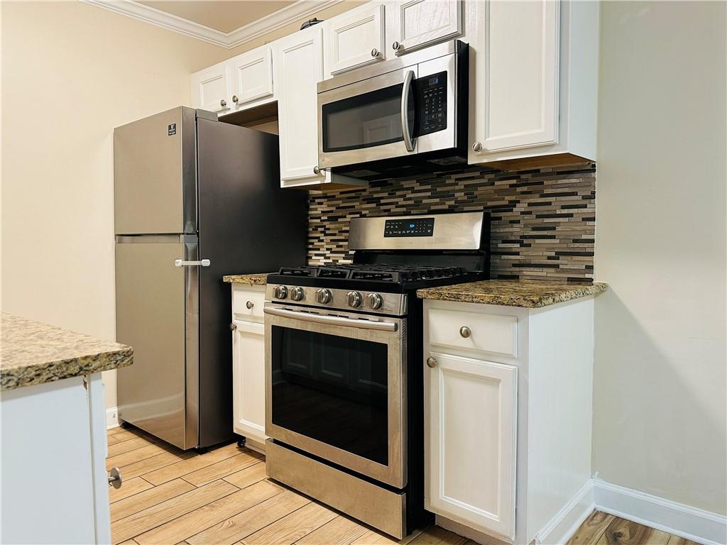 405 Fairburn Road Southwest, Unit 122 Atlanta, GA 30331 - Photo 5 of 26 a kitchen with stainless steel appliances granite countertop a stove microwave and a refrigerator