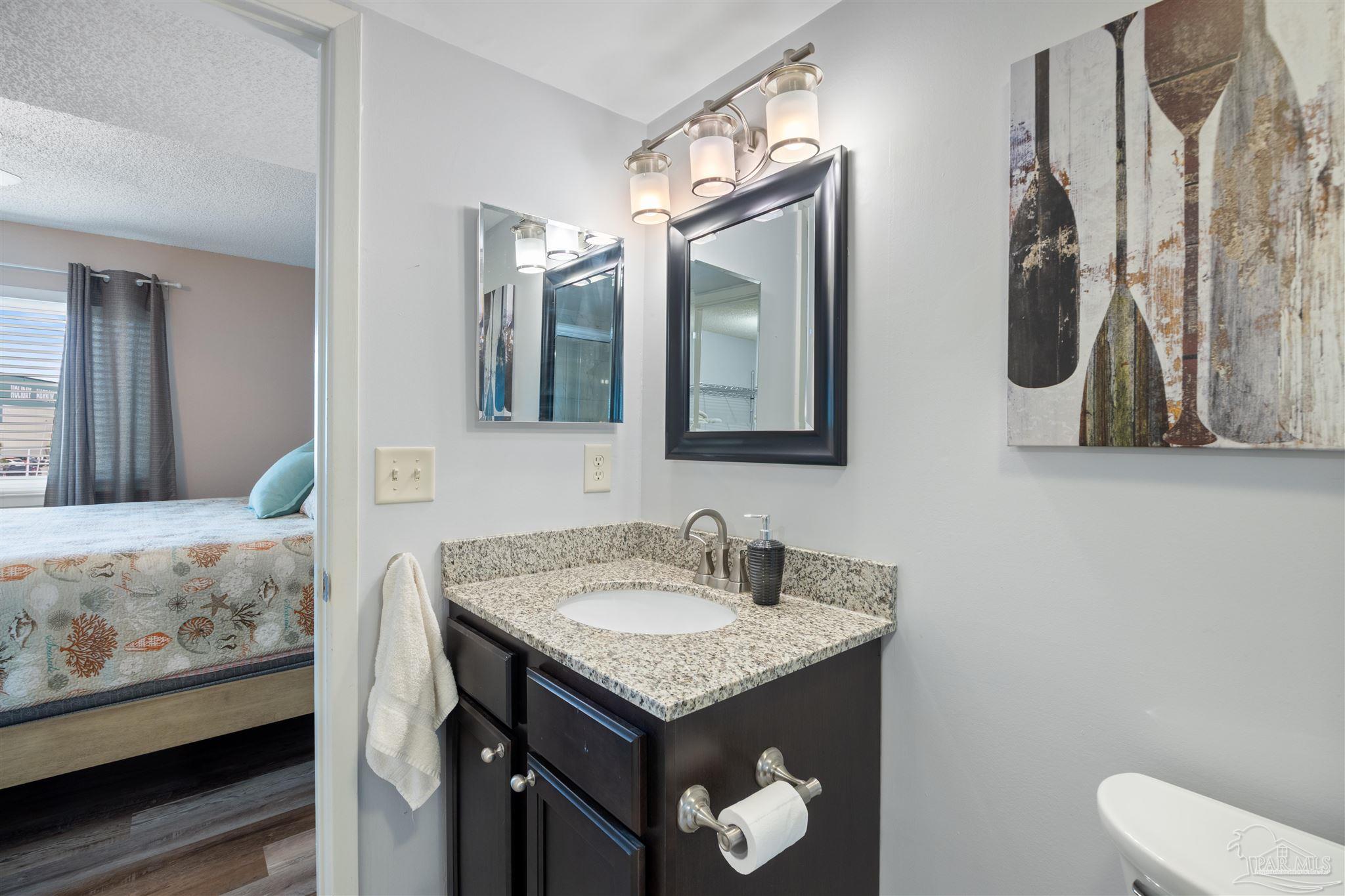 14100 River Road, Unit 228B Pensacola, FL 32507 - Photo 18 of 41 a bathroom with a granite countertop sink and a mirror