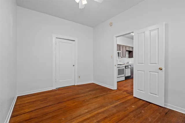 a view of empty room with wooden floor