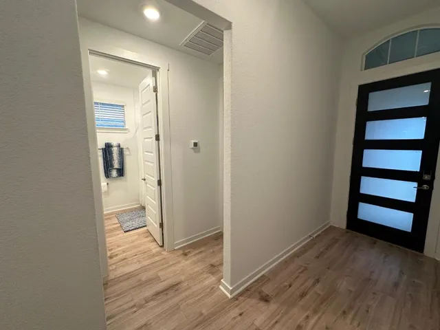 wooden floor in an empty room and a bathroom