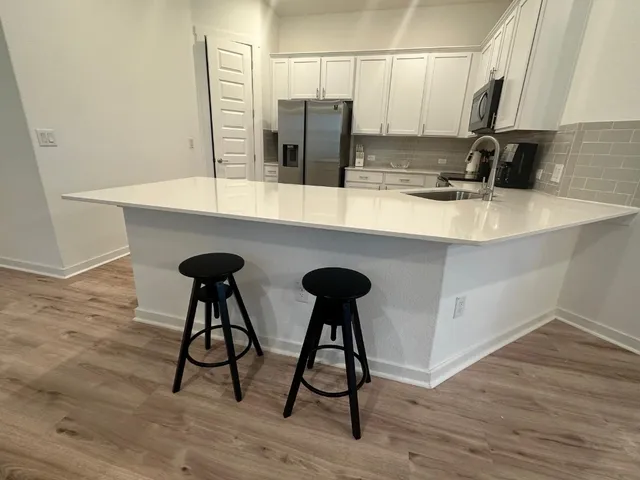 a kitchen with a sink cabinets and wooden floor