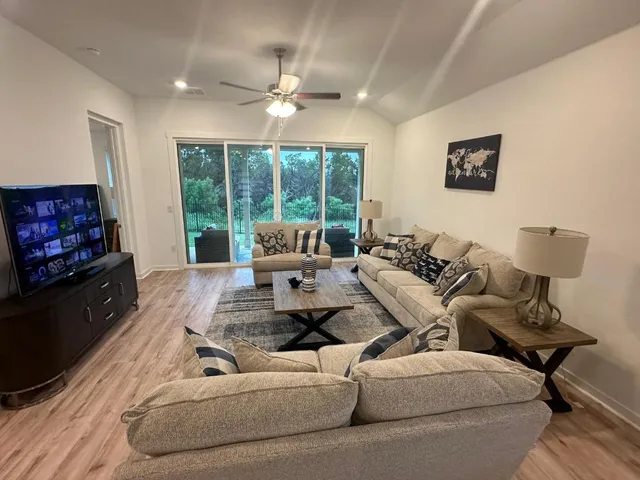a living room with furniture large window and flat screen tv