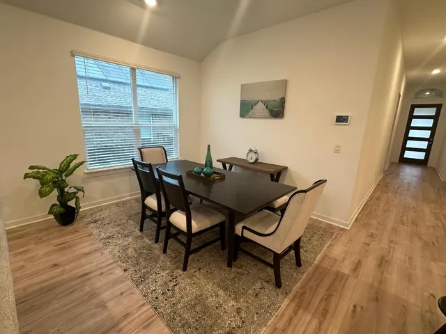 a dining room with furniture and wooden floor