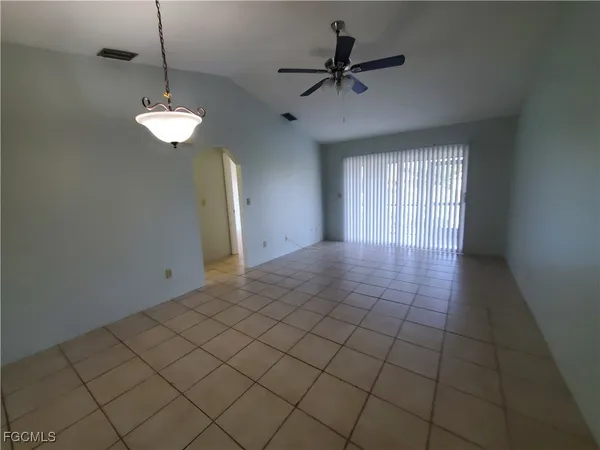 a view of a livingroom with a chandelier fan and windows