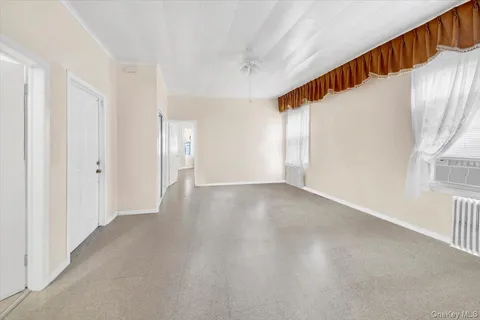 a view of an empty room with wooden floor and stairs