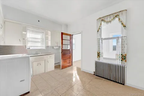 a bathroom with a granite countertop sink a bathtub and a window