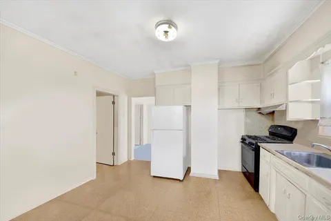 a kitchen with a refrigerator a stove top oven and cabinets