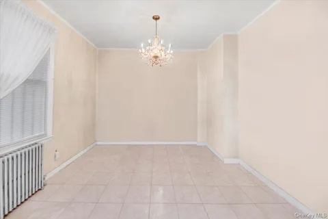 a view of an empty room with chandelier fan
