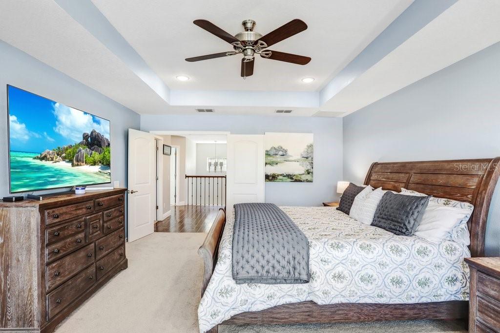 11719 Albatross Lane Riverview, FL 33569 - Photo 33 of 51 a bedroom with a large bed and a flat screen tv