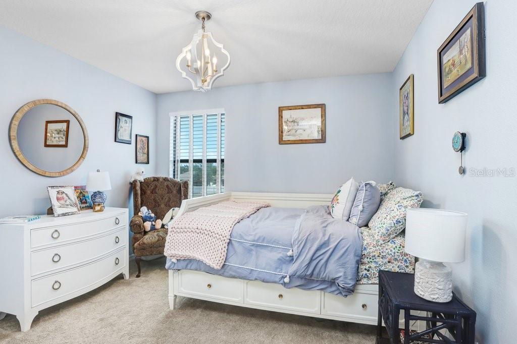 11719 Albatross Lane Riverview, FL 33569 - Photo 38 of 51 a bedroom with a bed and a chandelier