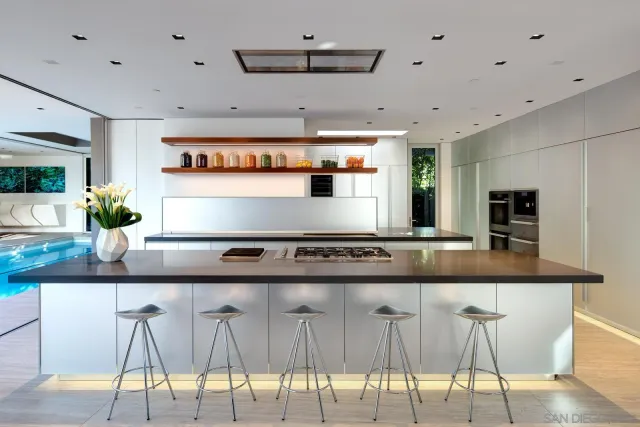 a kitchen with granite countertop white cabinets and chairs