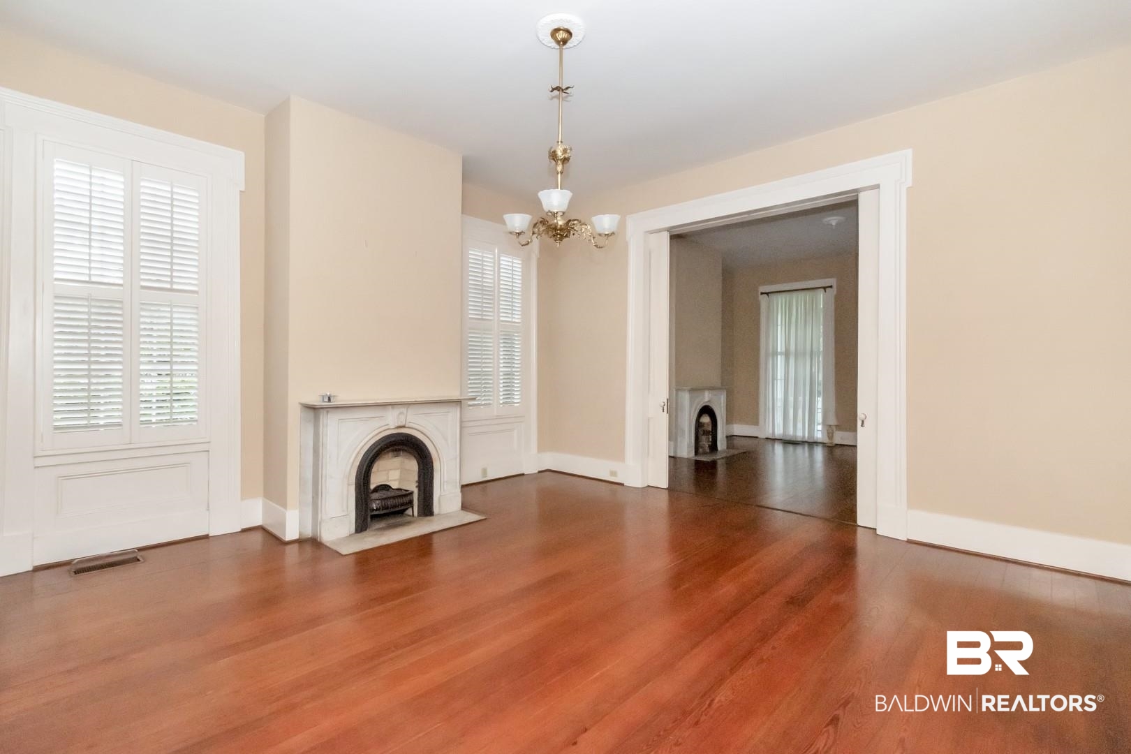 959 Dauphin Street Mobile, AL 36604 - Photo 7 of 43 Unfurnished living room with an inviting chandelier and hardwood / wood-style flooring