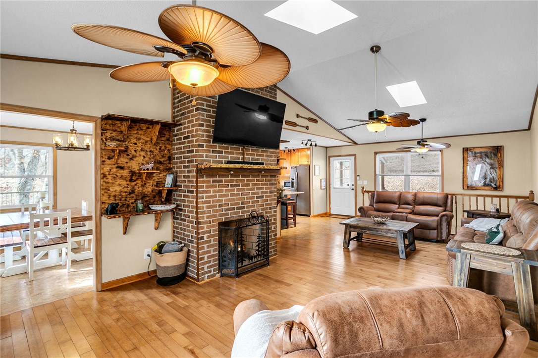 130 Greenbrier Road Salem, SC 29676 - Photo 2 of 42 This inviting interior features natural wood floors and a charming brick fireplace, creating a warm ambiance.