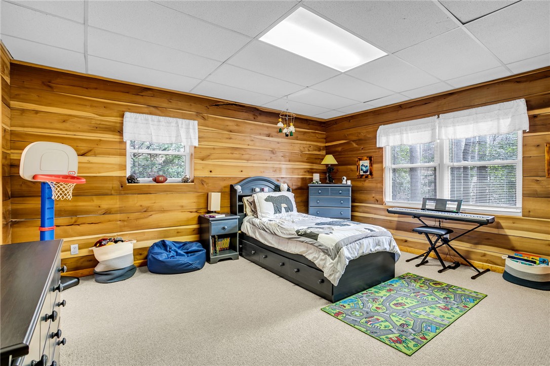 130 Greenbrier Road Salem, SC 29676 - Photo 34 of 42 This cozy bedroom features warm wood paneling and ample natural light, creating a comfortable atmosphere.