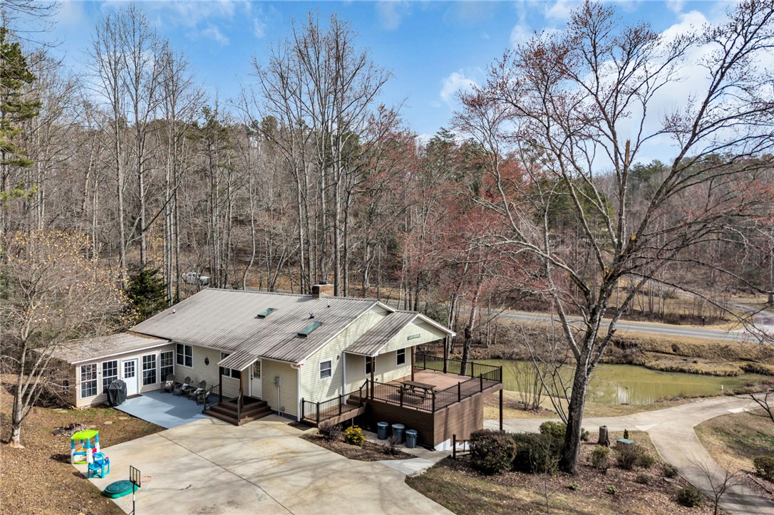 130 Greenbrier Road Salem, SC 29676 - Photo 40 of 42 This charming home features an expansive deck, perfect for outdoor living, overlooking a serene pond.