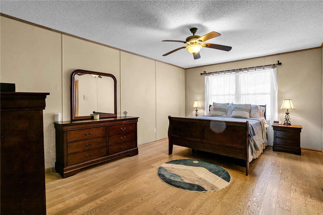130 Greenbrier Road Salem, SC 29676 - Photo 7 of 42 This spacious bedroom offers ample natural light and enduring wood flooring, creating a comfortable living space.