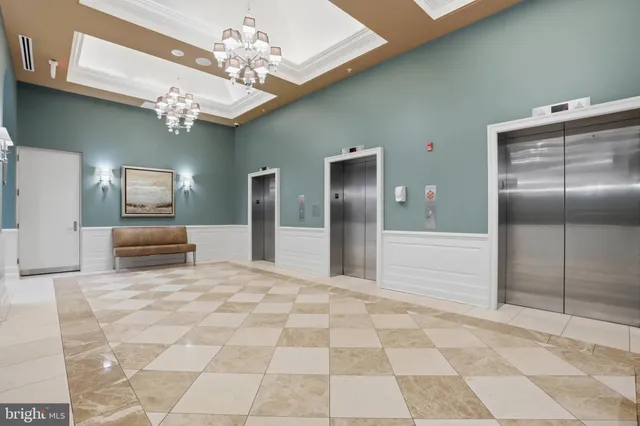 a view of a hallway with a chandelier and living room