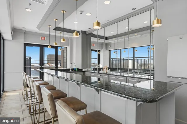 a kitchen with granite countertop a sink and chairs