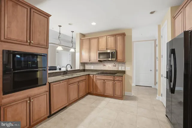 a kitchen with stainless steel appliances granite countertop a refrigerator sink and cabinets