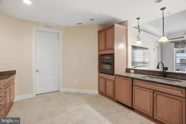 a kitchen with stainless steel appliances granite countertop a sink and white cabinets