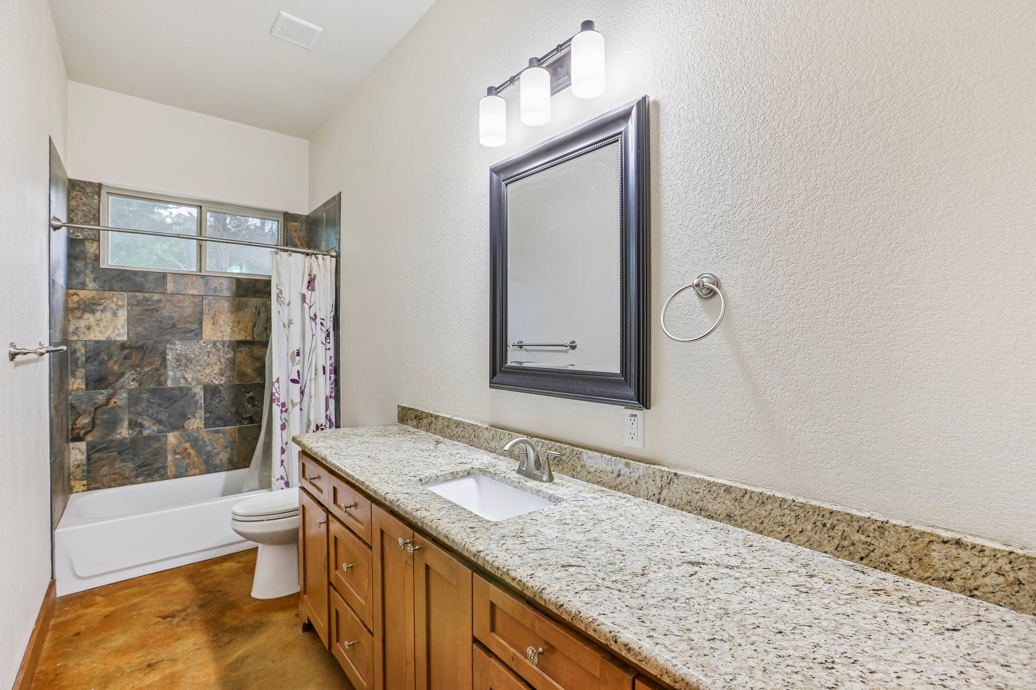 267 Corral Road Smithville, TX 78957 - Photo 22 of 40 Bathroom featuring an extended wood-finish vanity with a light speckled countertop and undermount sink