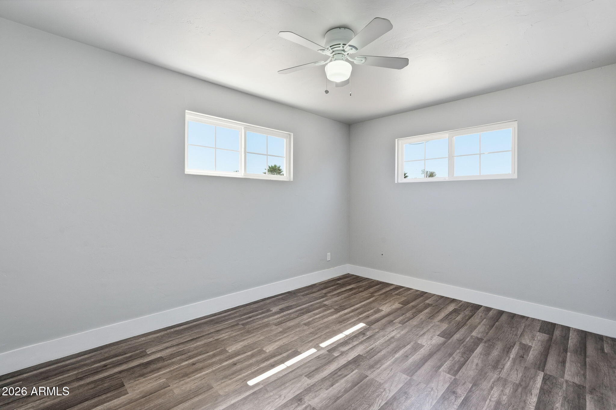 2206 West Rancho Drive Phoenix, AZ 85015 - Photo 15 of 29 a view of a room with wooden floor and a ceiling fan