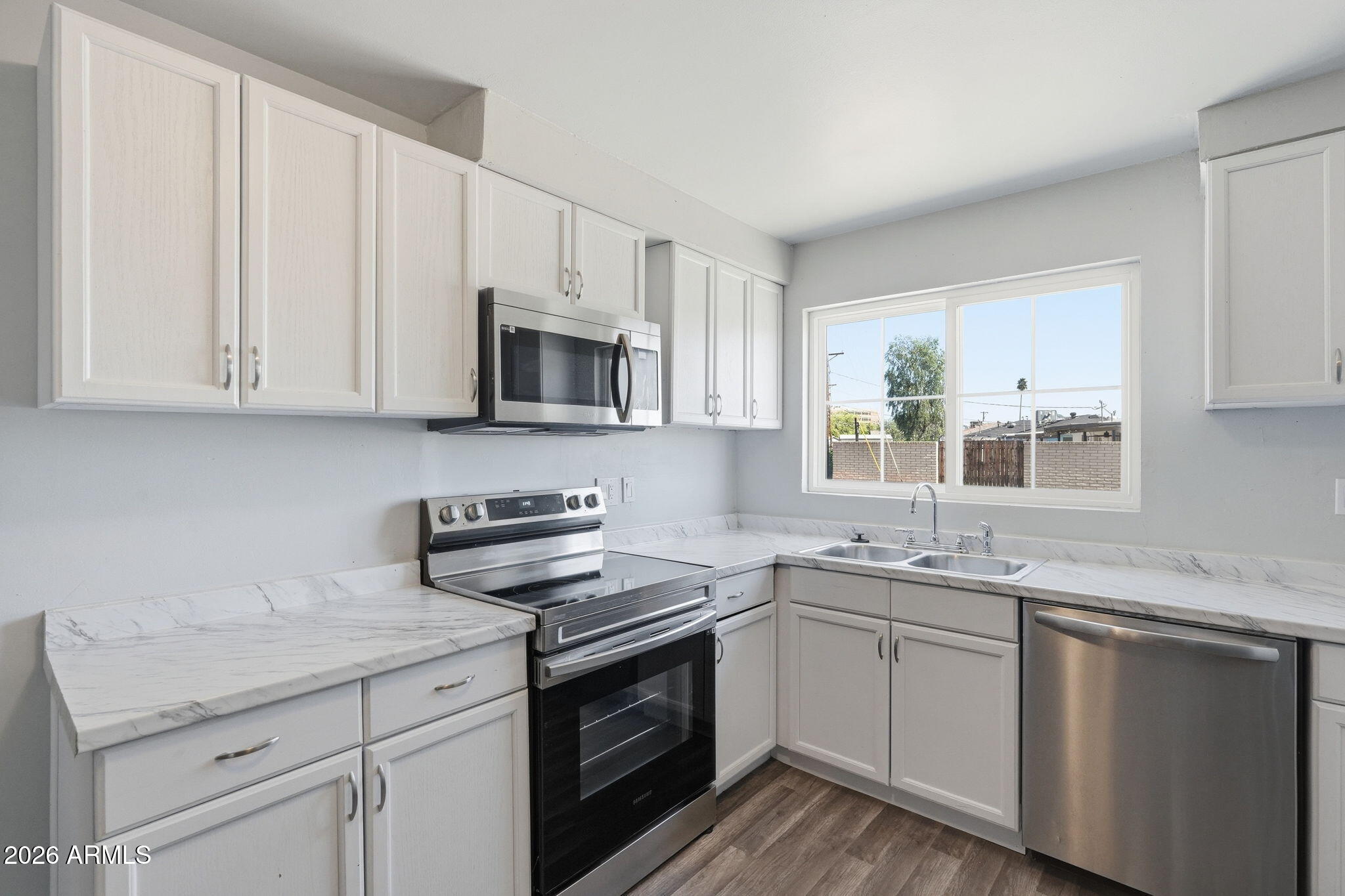 2206 West Rancho Drive Phoenix, AZ 85015 - Photo 2 of 29 a kitchen with stainless steel appliances granite countertop white cabinets a sink and dishwasher next to a window