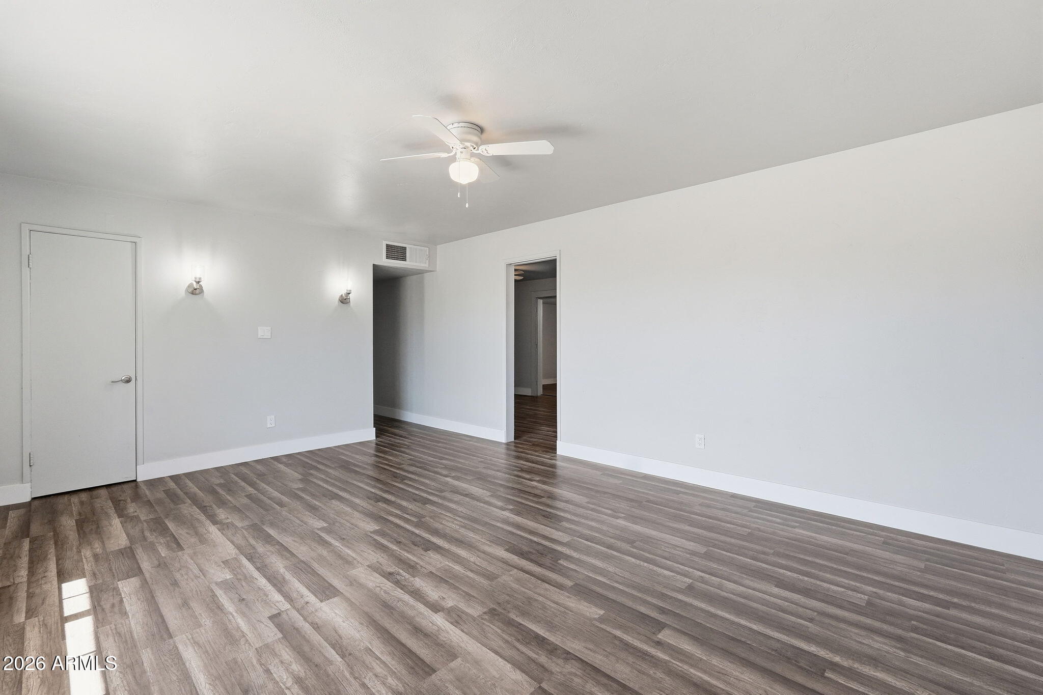 2206 West Rancho Drive Phoenix, AZ 85015 - Photo 22 of 29 a view of an empty room with wooden floor and a ceiling fan