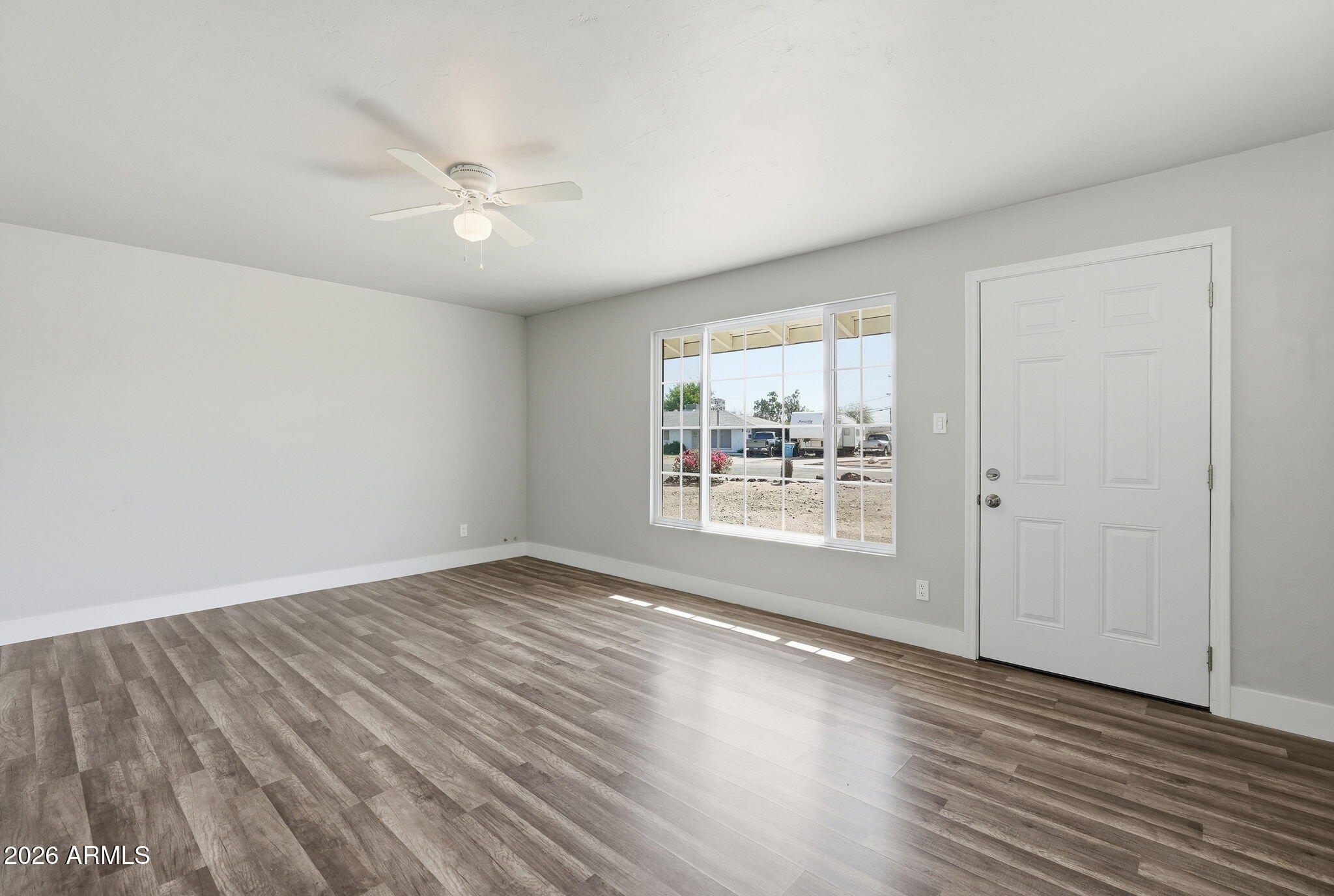 2206 West Rancho Drive Phoenix, AZ 85015 - Photo 4 of 29 an empty room with wooden floor and windows
