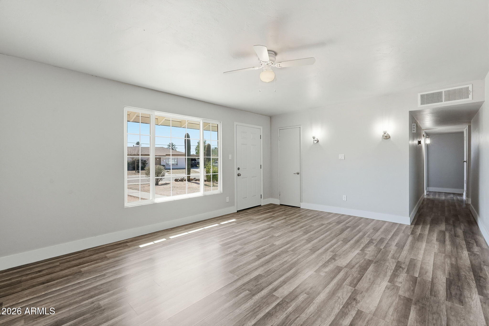 2206 West Rancho Drive Phoenix, AZ 85015 - Photo 6 of 29 a view of an empty room with wooden floor and a window