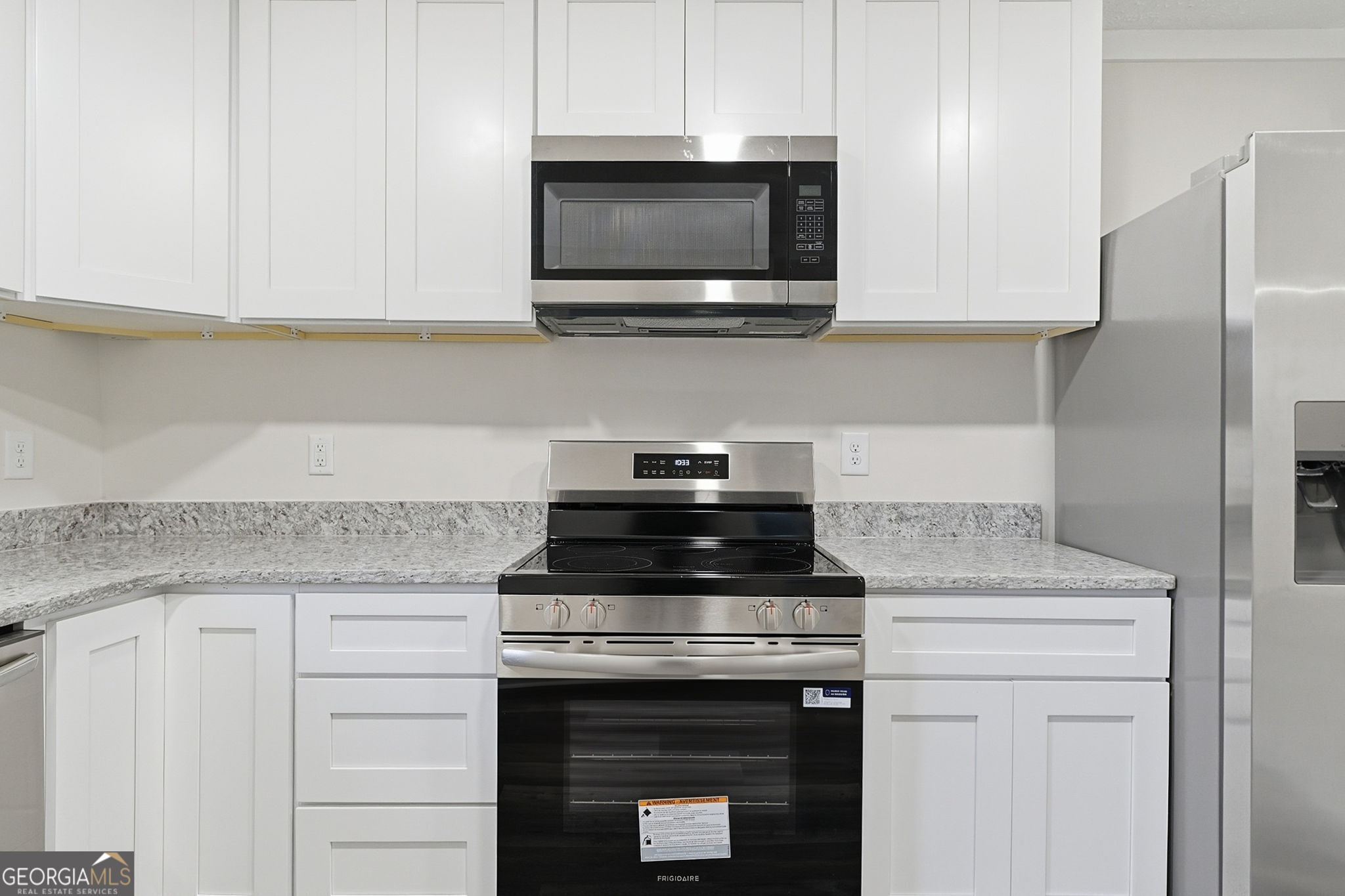 1734 Ball Ground Road Ball Ground, GA 30107 - Photo 19 of 31 a kitchen with stainless steel appliances granite countertop white cabinets granite counter tops and a wooden floors