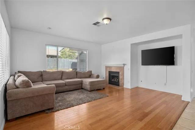 a living room with furniture and a large window with kitchen view