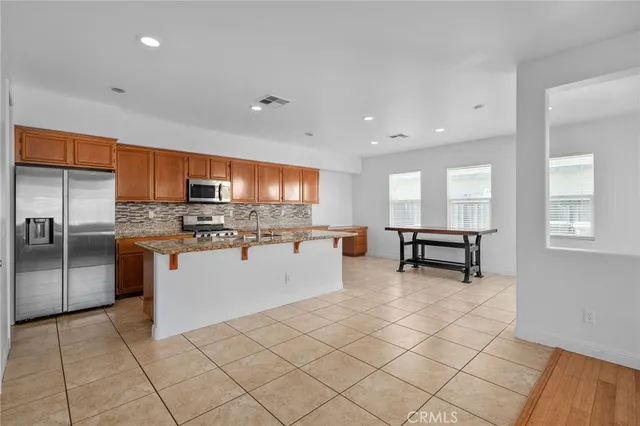 a kitchen with stainless steel appliances granite countertop a stove top oven a sink a counter space and cabinets