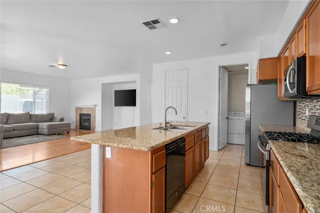 a kitchen with stainless steel appliances granite countertop a stove a sink and a microwave