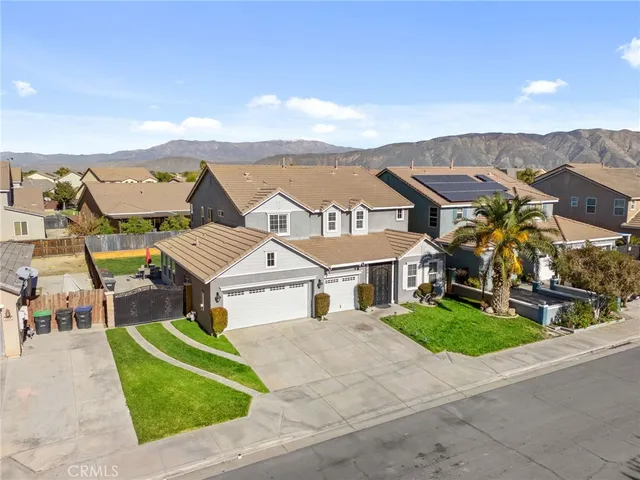 a view of a house with a small yard and a large parking space