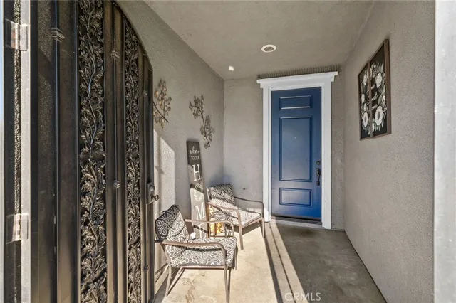 a hallway with wooden floor a glass table and chairs