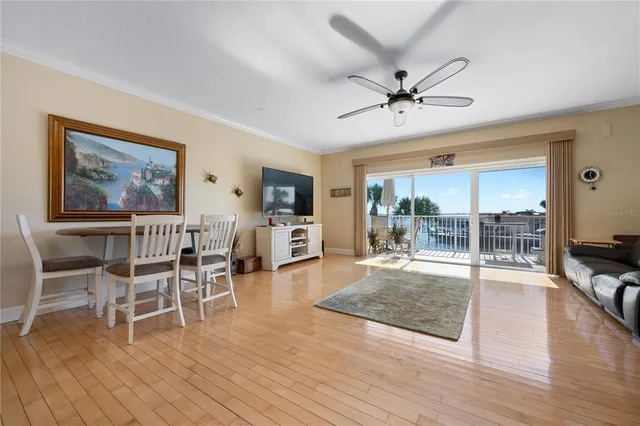 a living room with furniture a flat screen tv and a floor to ceiling window